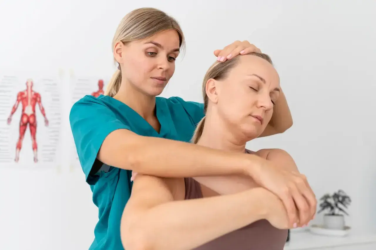 Fizjoterapeutka wykonuje masaż szyi pacjentki, stosując metody neurofizjologiczne.